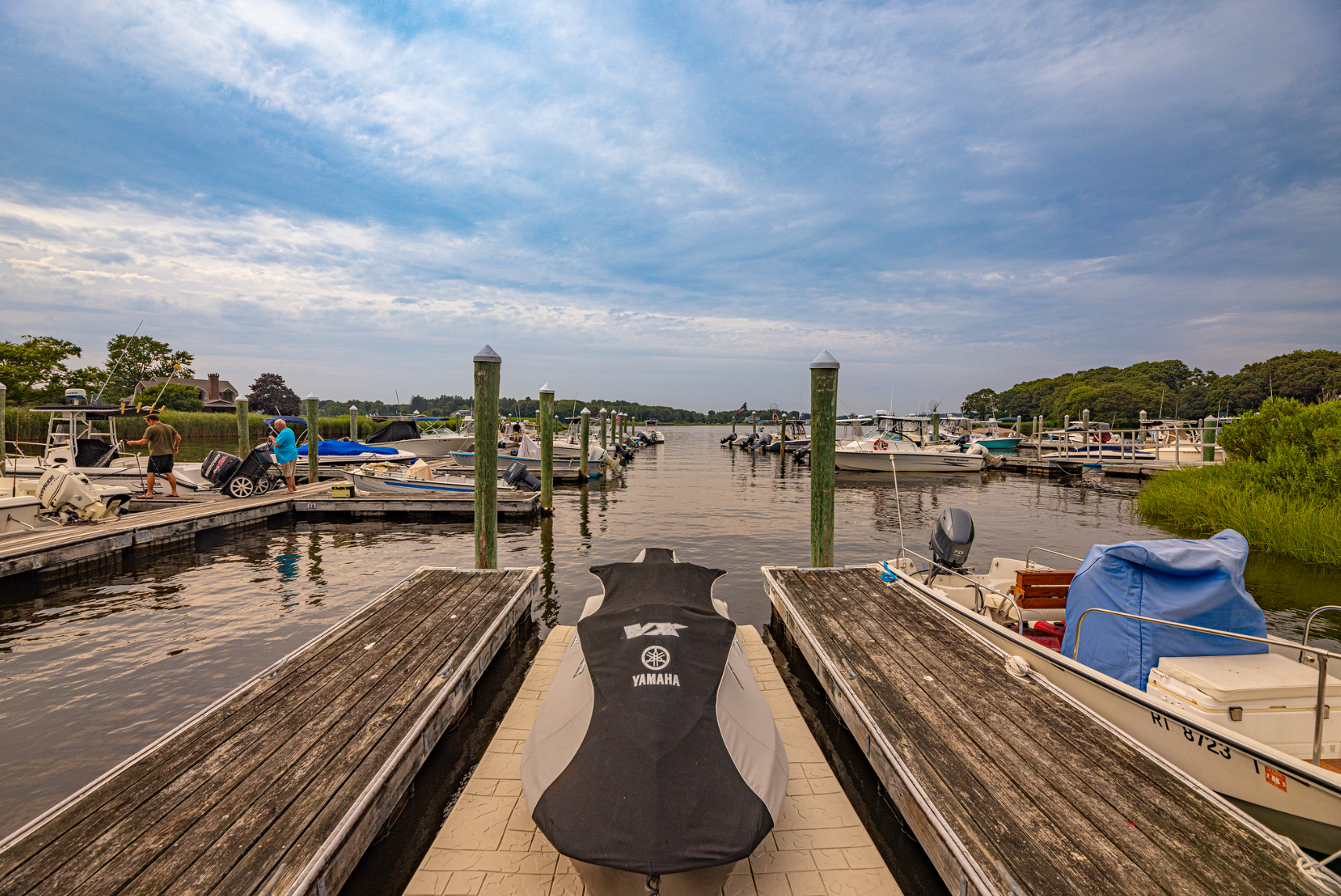A boat is docked at a dock next to a body of water.