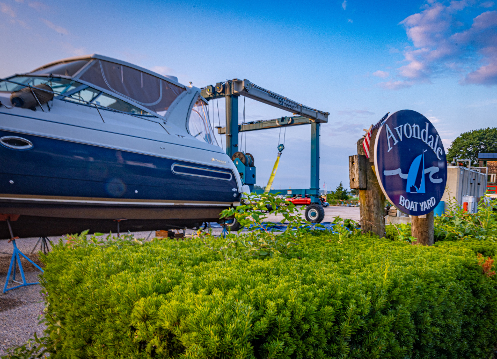 A boat is sitting on a lift next to a sign.