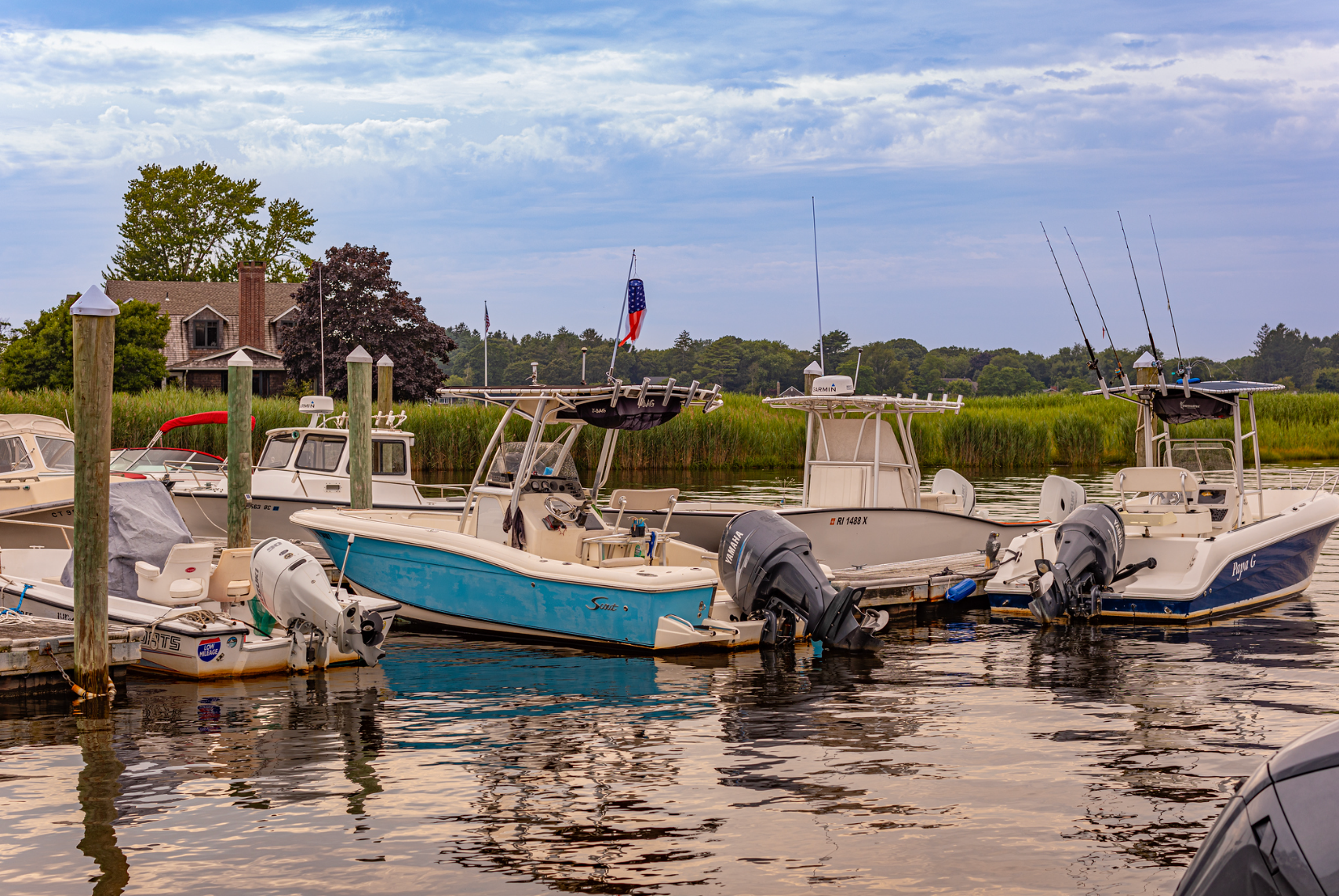 A group of boats are docked in a harbor.