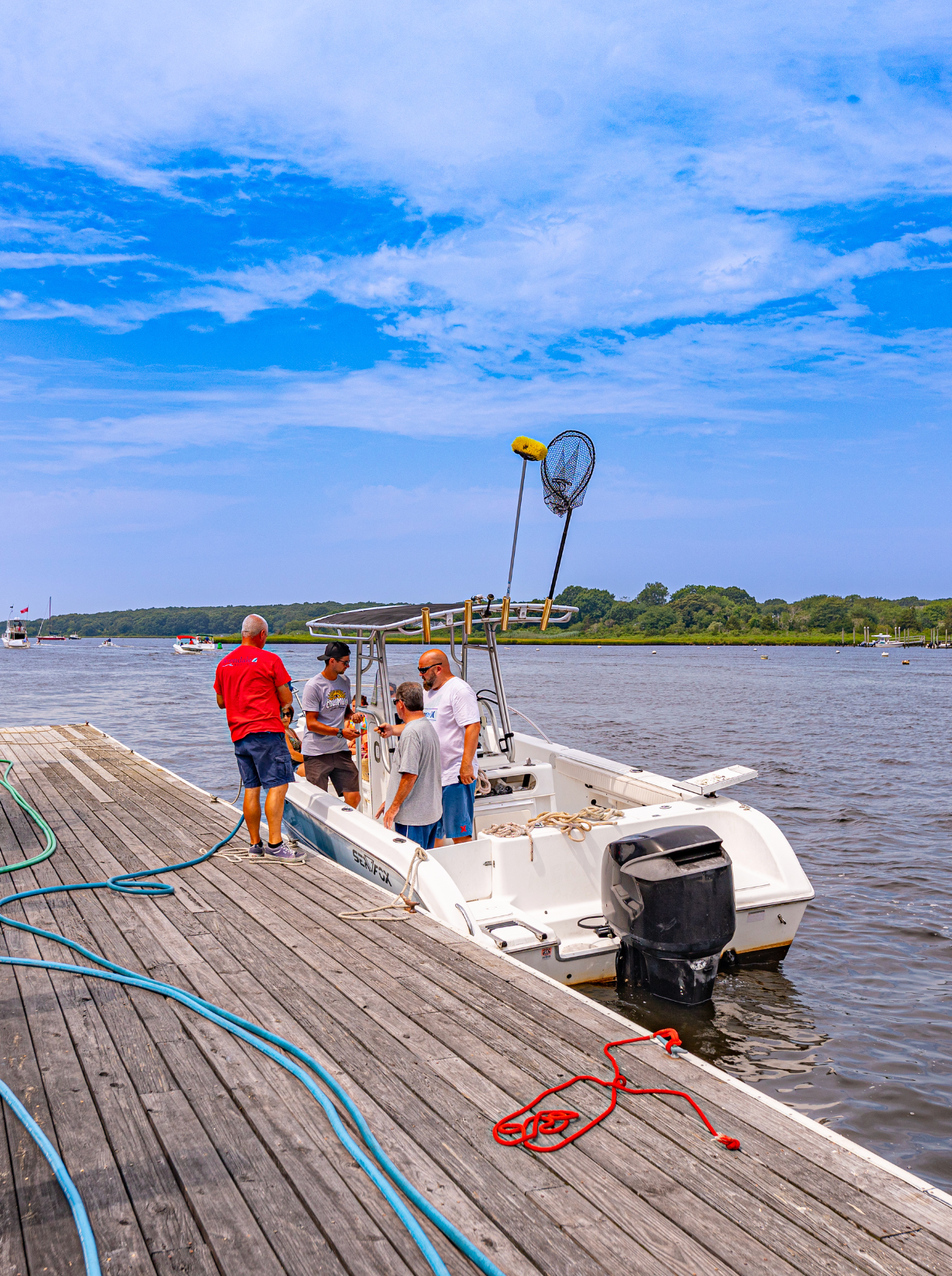 A group of men are standing on a dock next to a boat.