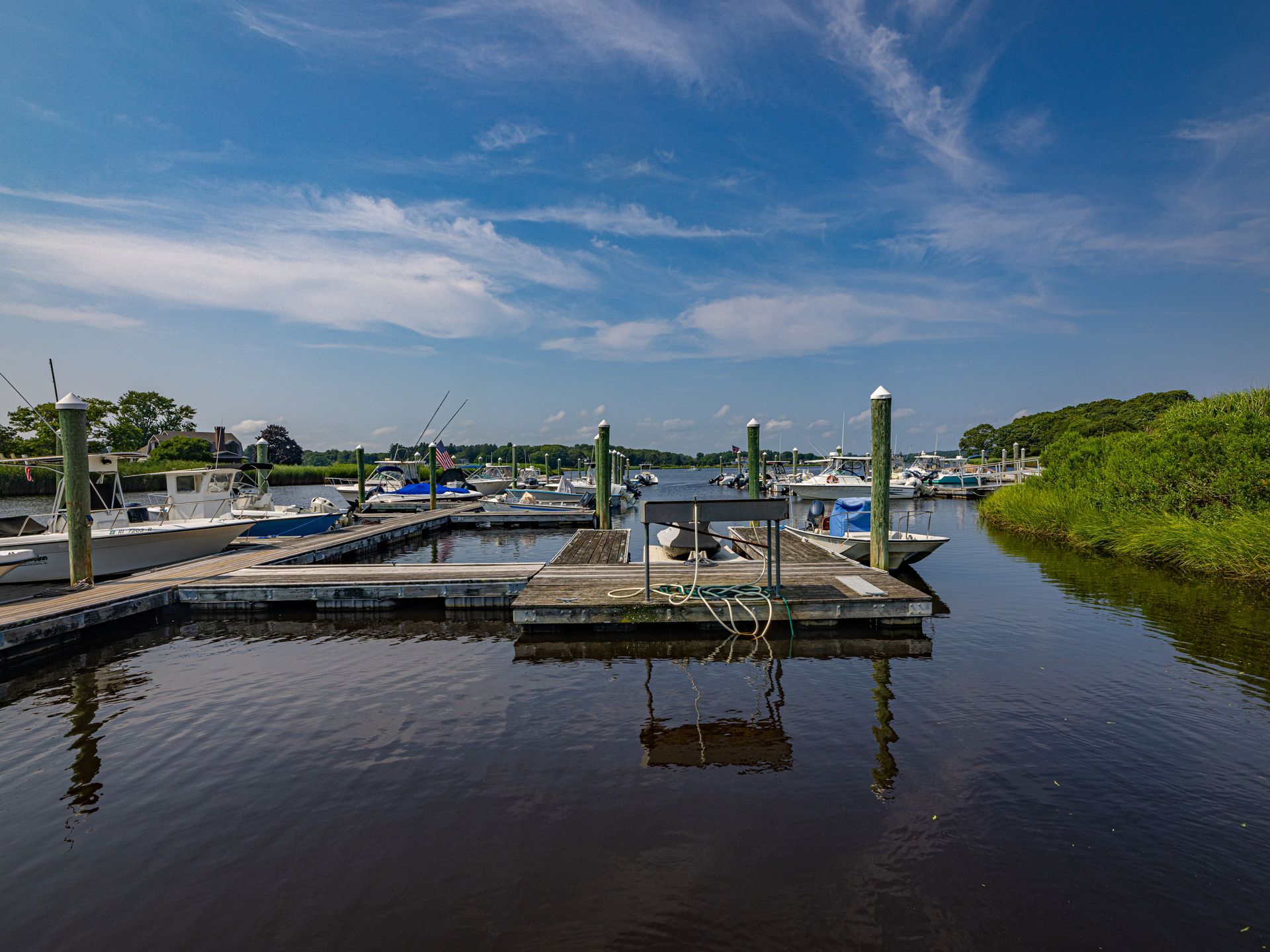 A marina with boats docked at a dock on a sunny day