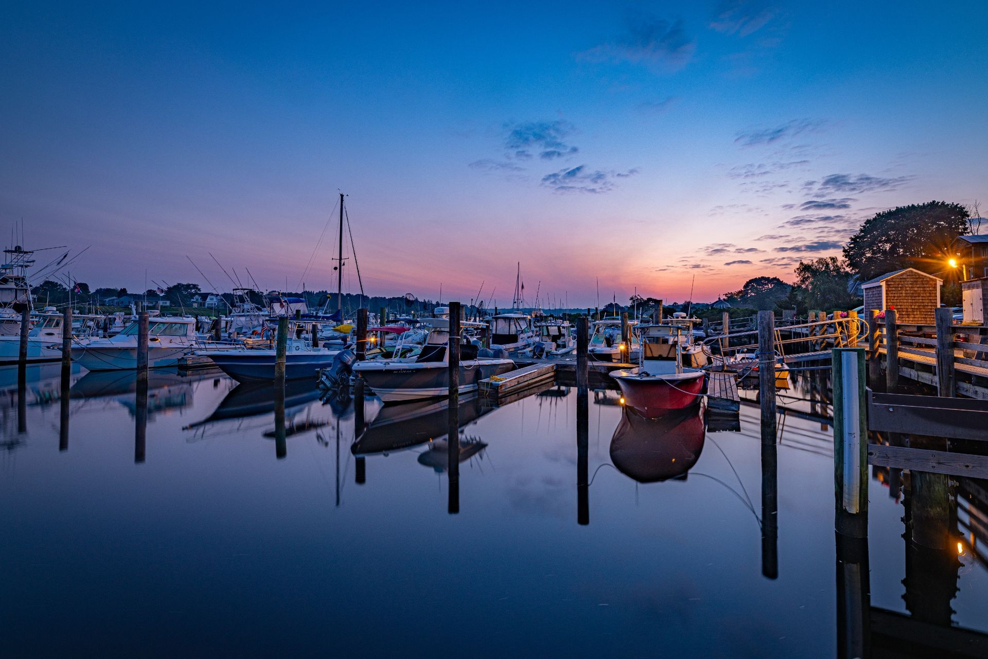 A marina filled with boats and a sunset in the background.