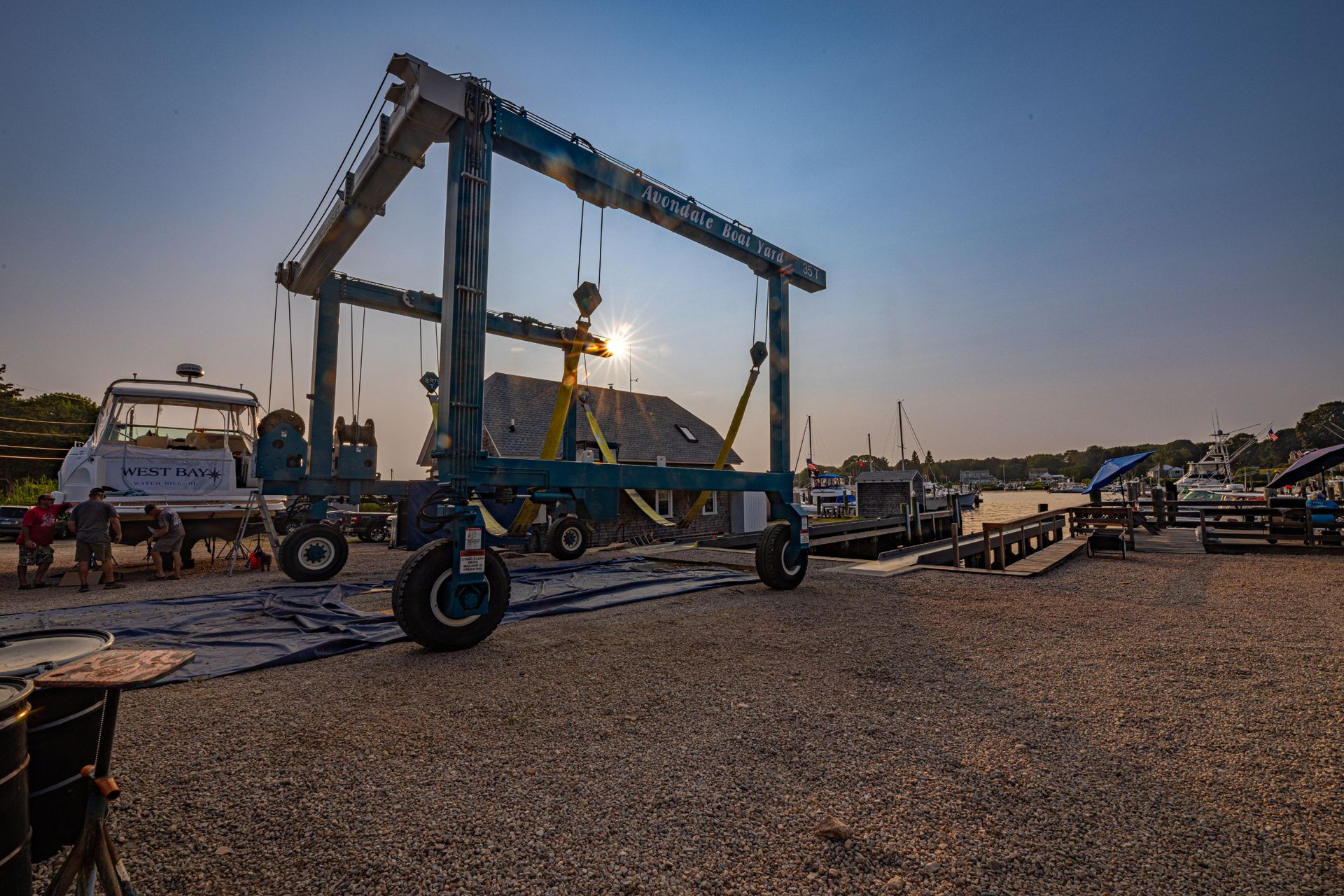 A large crane is being used to lift a boat in a marina.