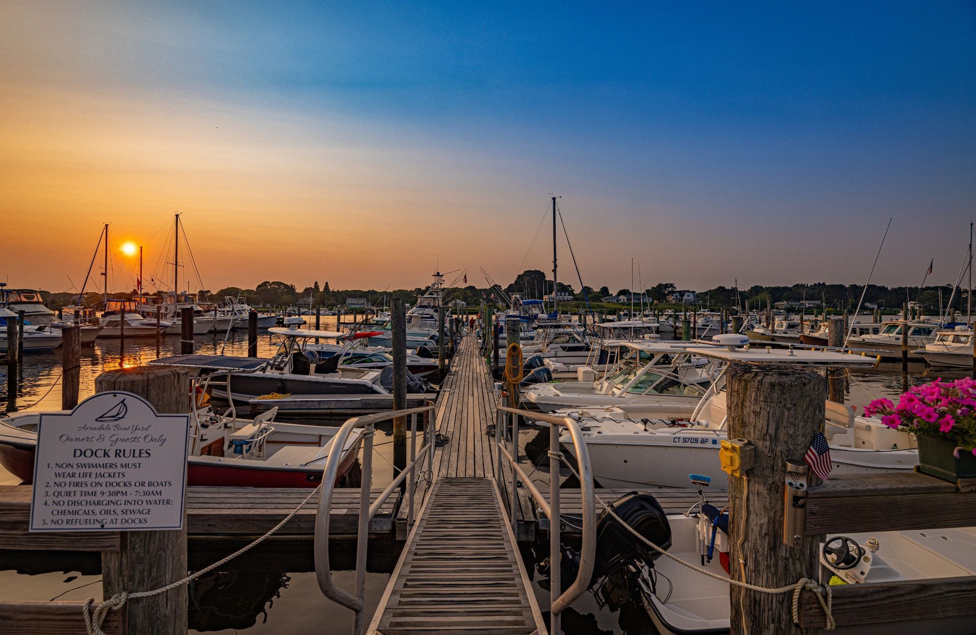 A marina filled with lots of boats at sunset.