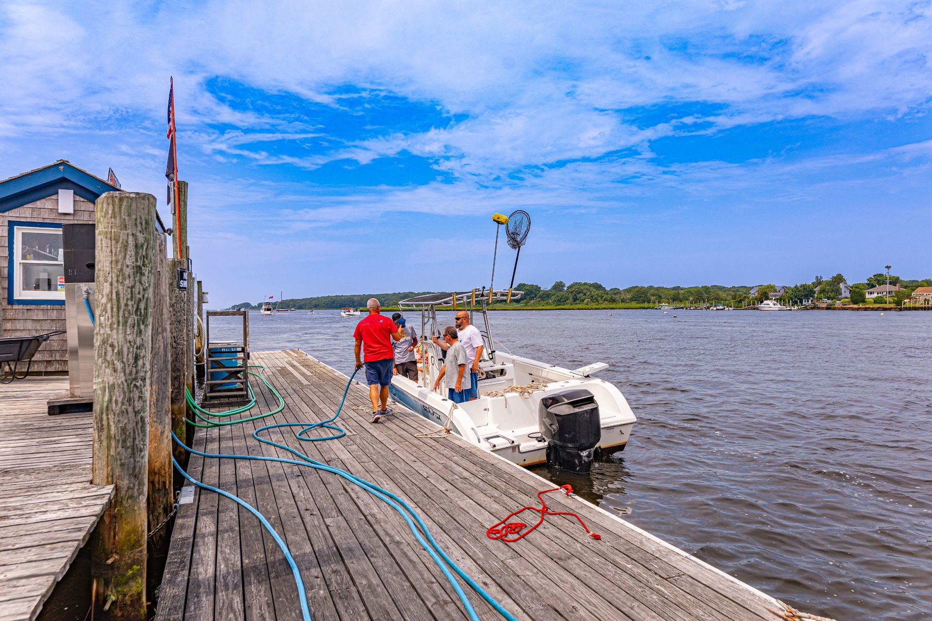 A group of people are walking towards a boat docked at a dock.