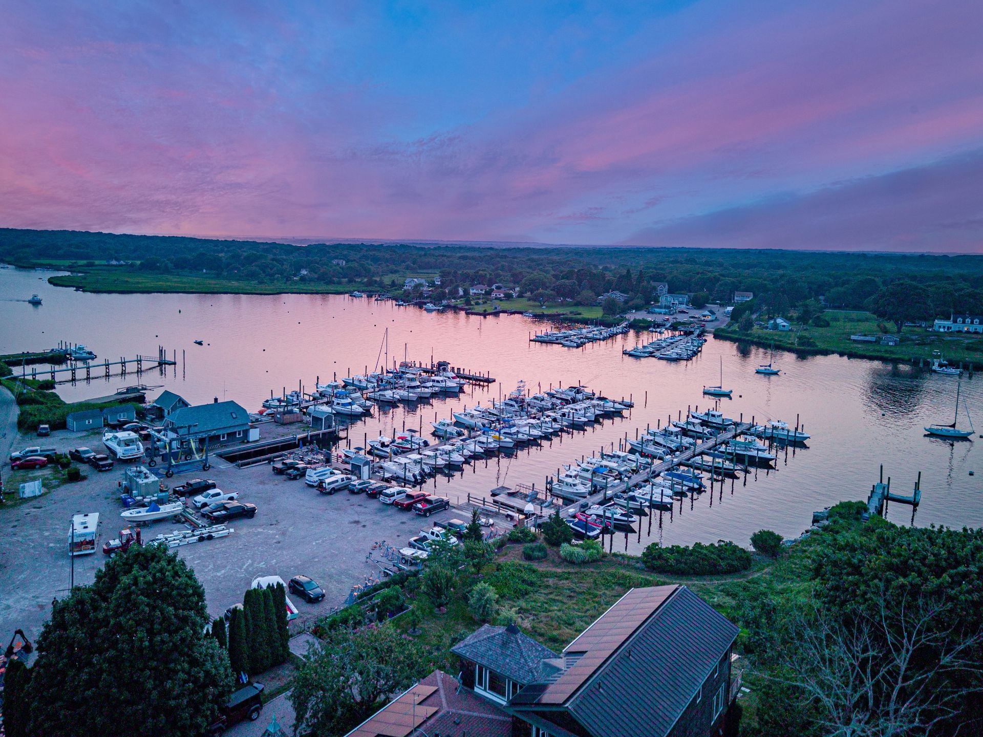 An aerial view of a marina filled with boats at sunset.