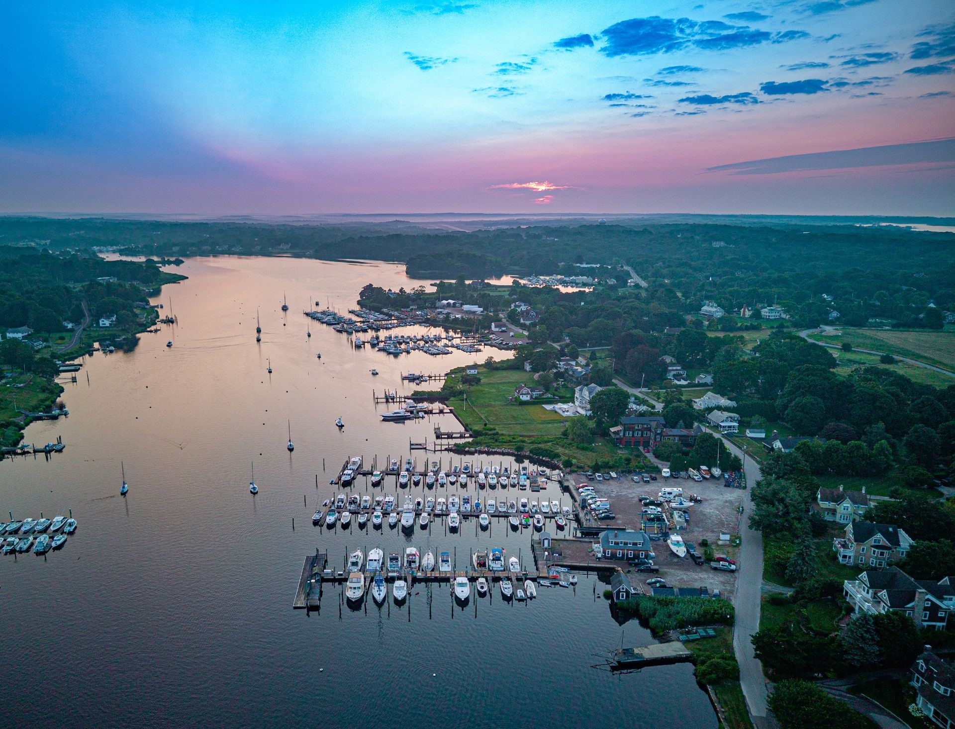 An aerial view of a marina with boats docked at sunset.