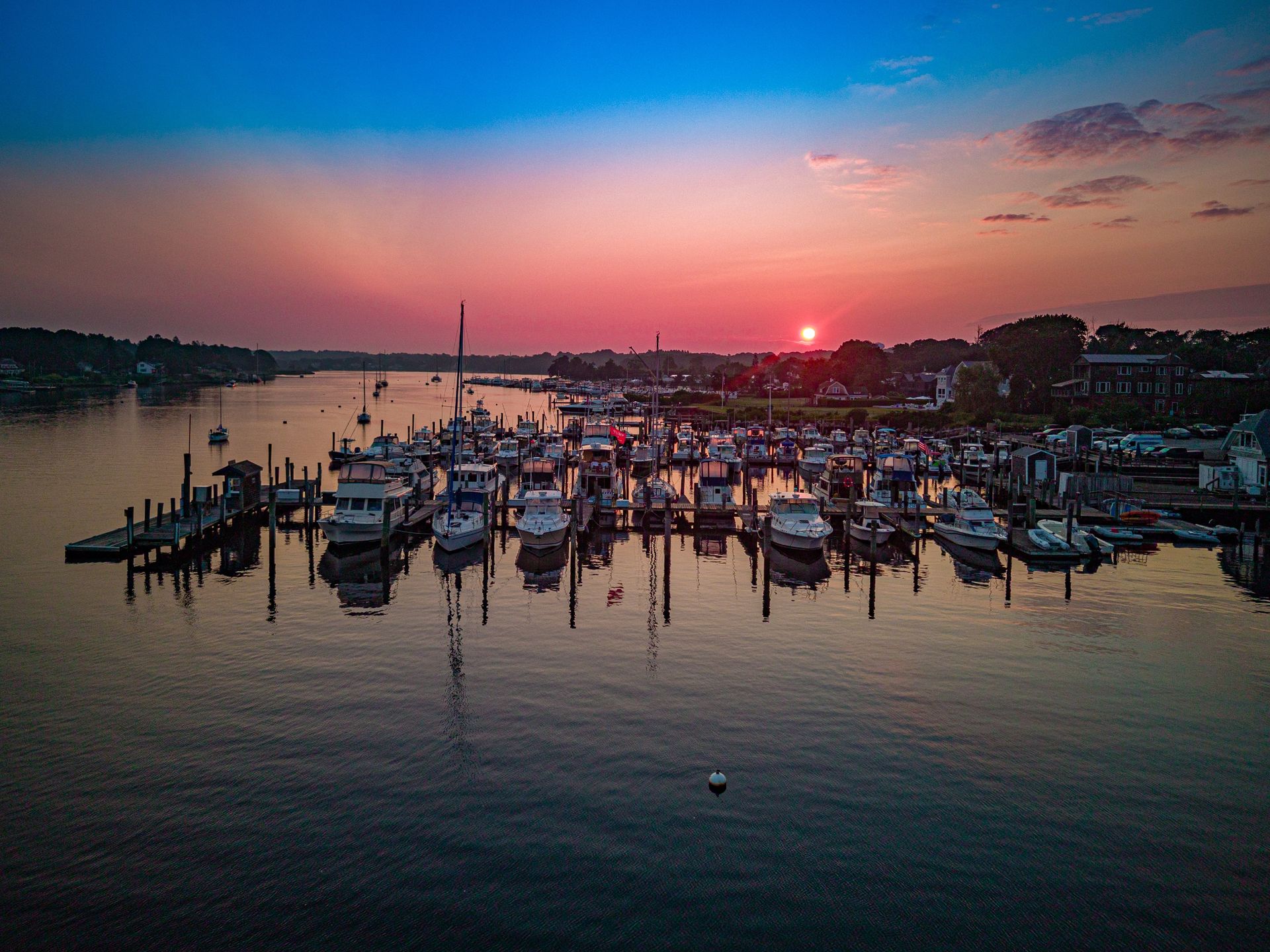 An aerial view of a marina with boats docked at sunset.