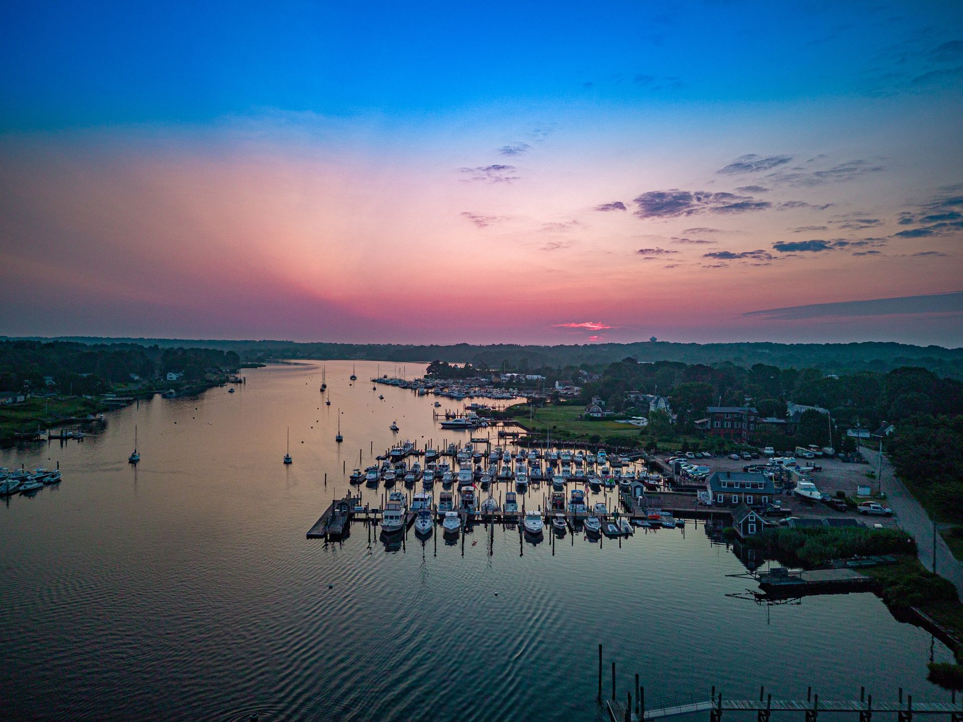 An aerial view of a marina with boats docked at sunset.
