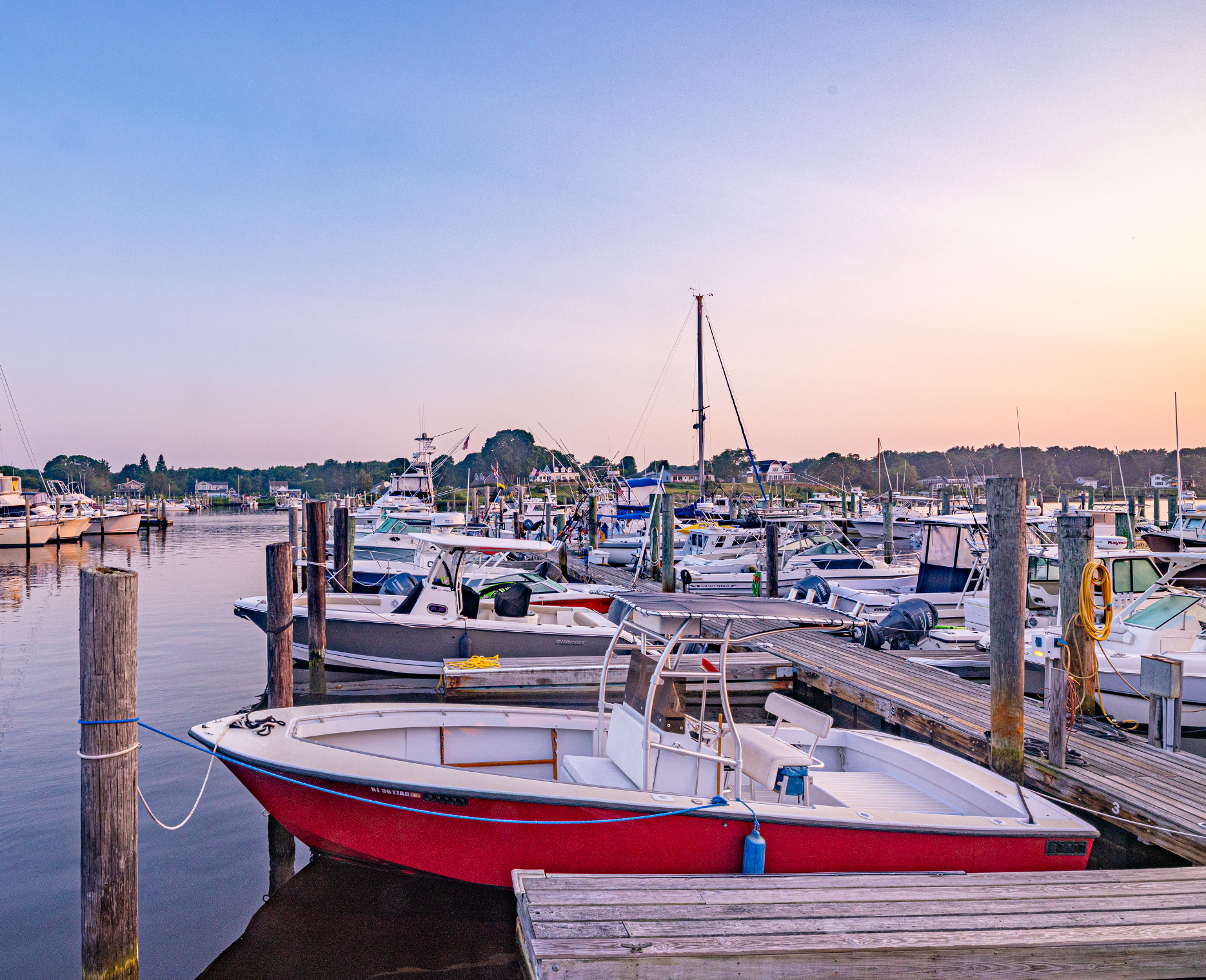 A red and white boat is docked at a marina