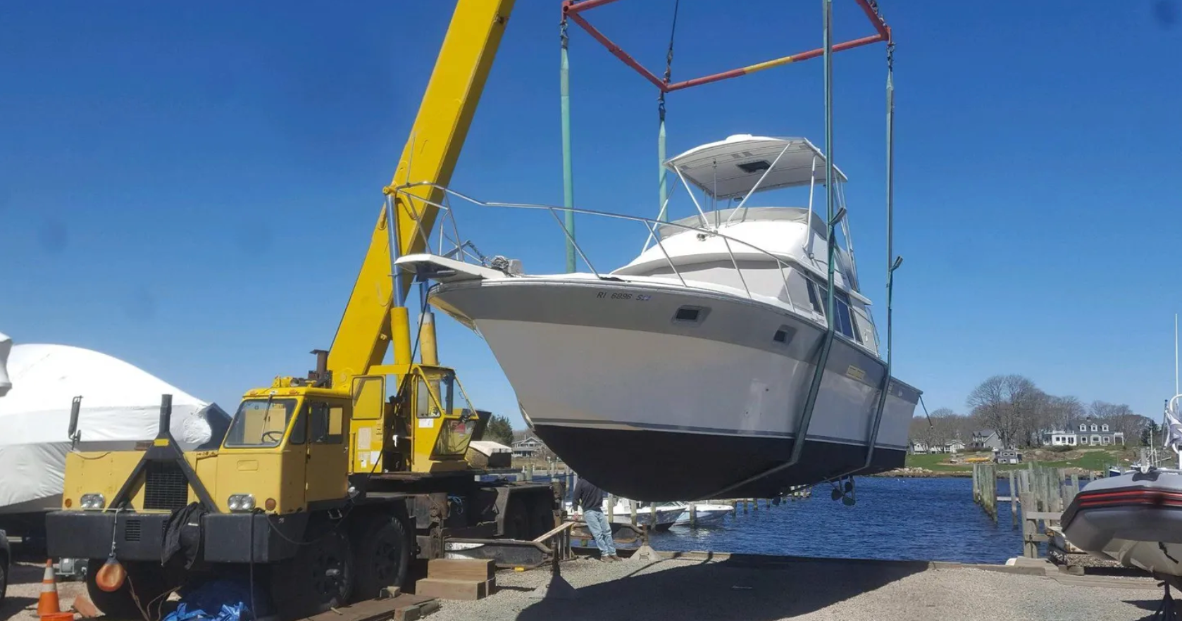 A boat is being lifted into the water by a crane.