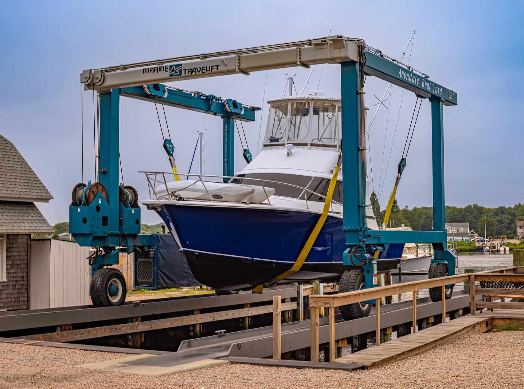 A blue boat is sitting on top of a crane.