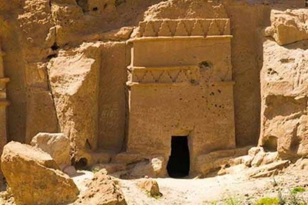 A cave in the middle of a desert surrounded by rocks and sand.