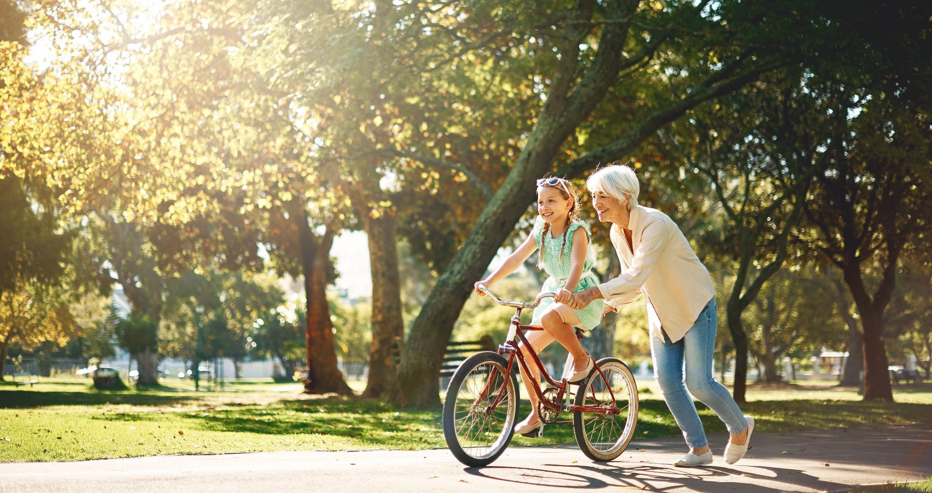 Grandmother teaching her granddaughter to ride a bike