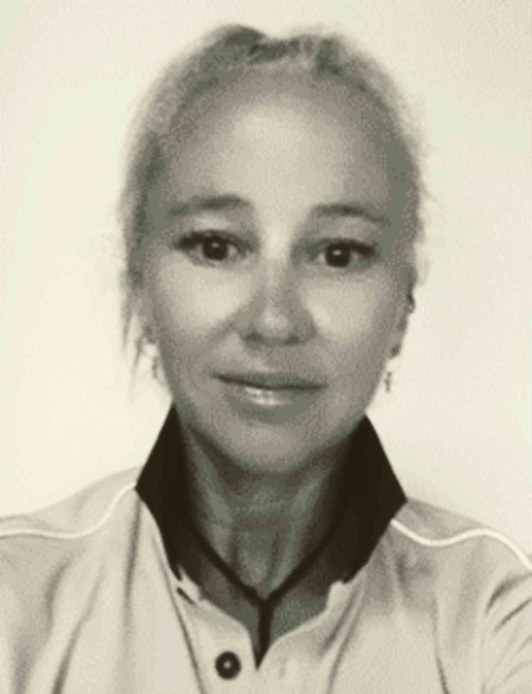 Portrait of a person wearing a light shirt, facing forward against a plain background.