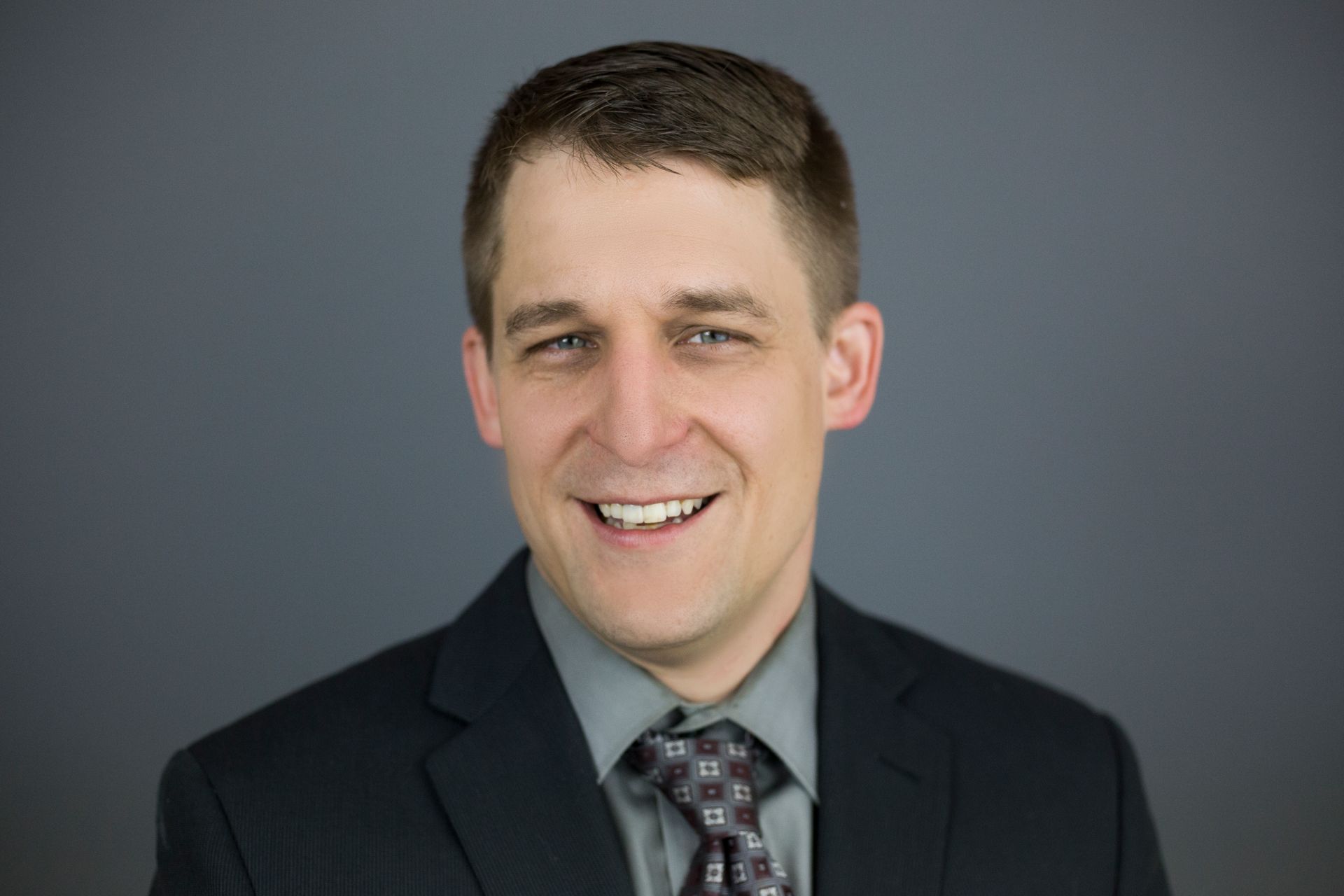 A man in a suit and tie is smiling for the camera.