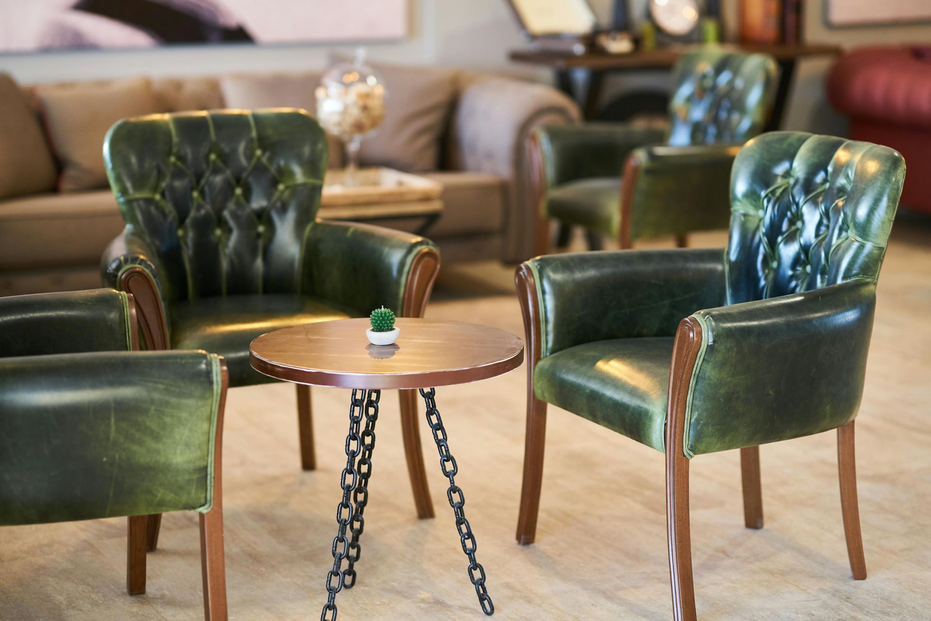 A living room with green chairs and a small table