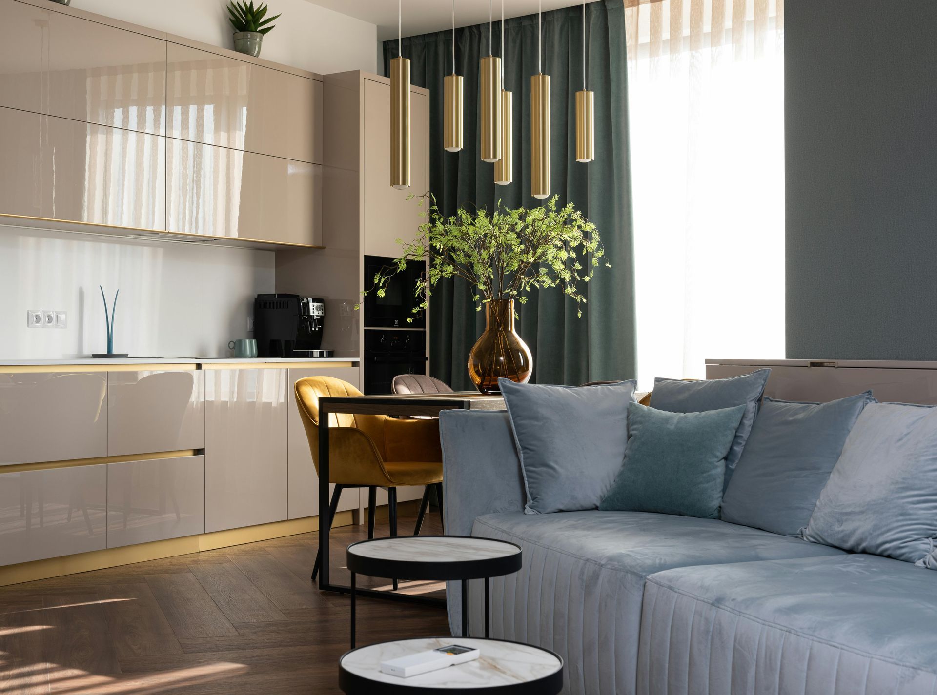 A living room with a couch , table , chairs and a kitchen.