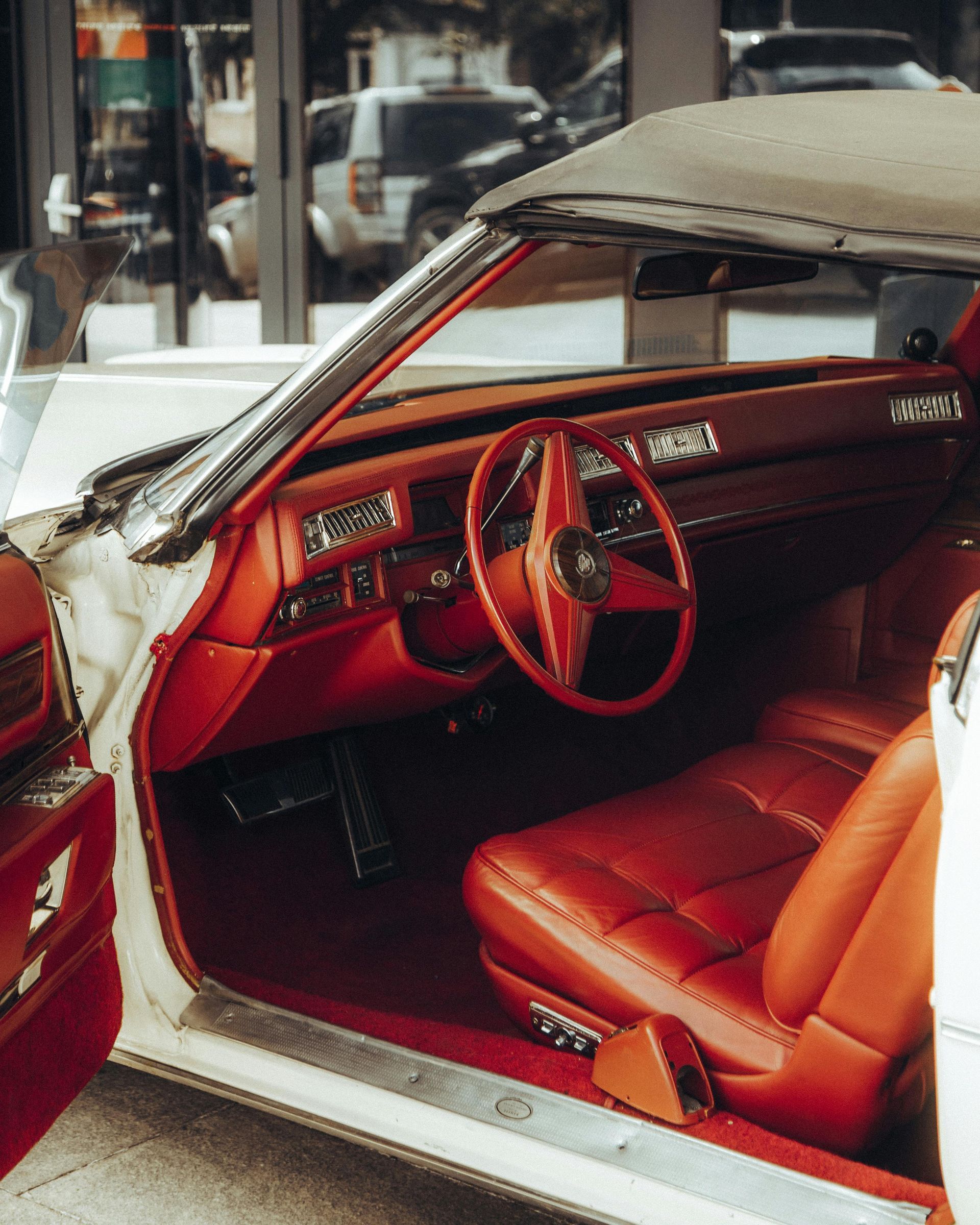 A white car with red seats and a steering wheel