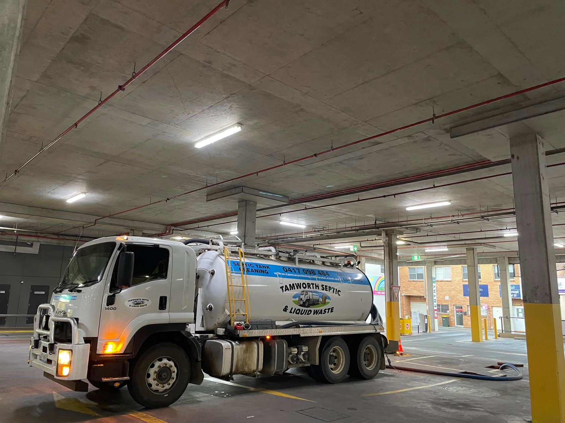 White Tanker Truck Parked in An Indoor Garage — Tamworth Septic & Liquid Waste in Duri, NSW