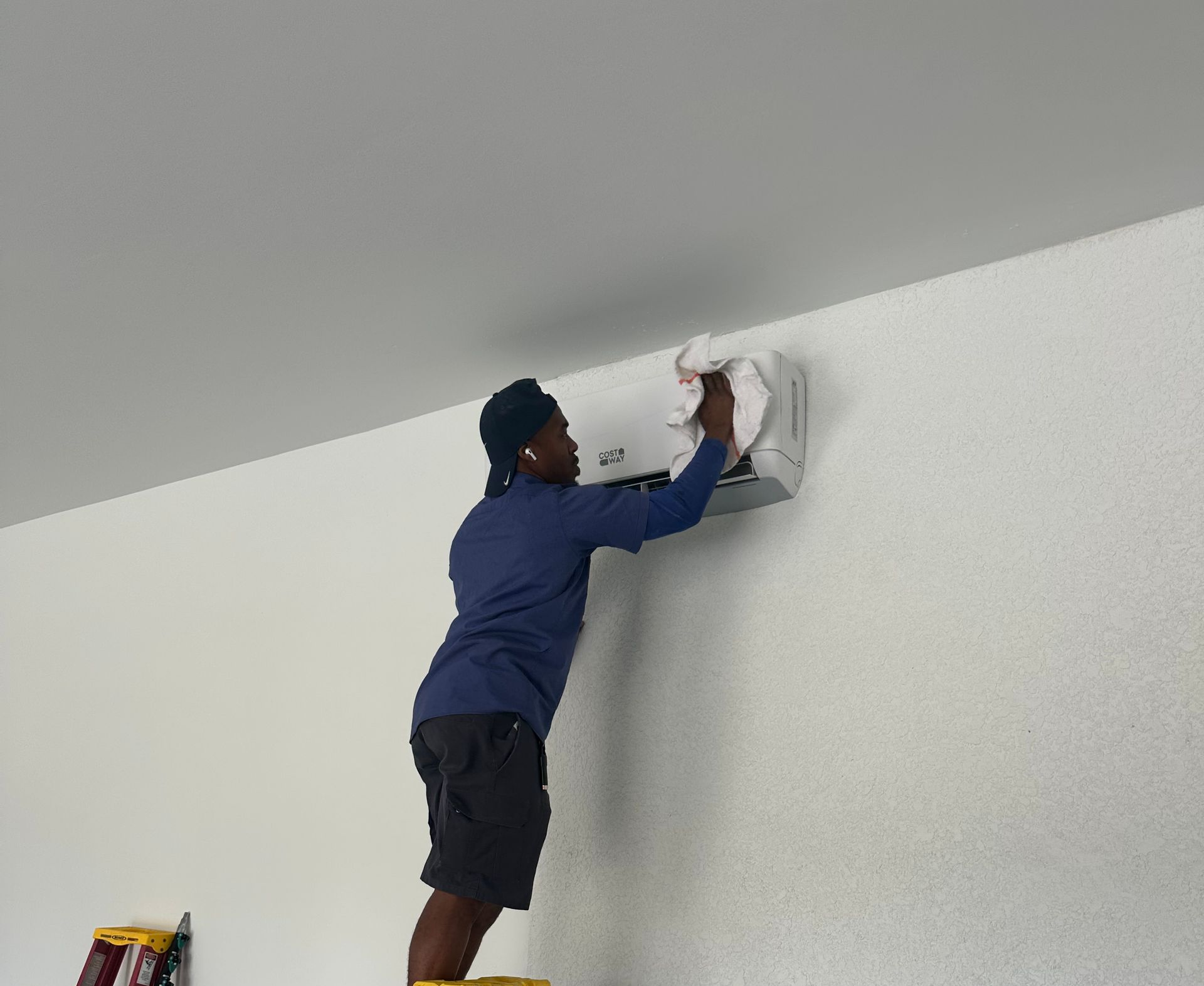 Siggs technician installing a garage mini split hvac system