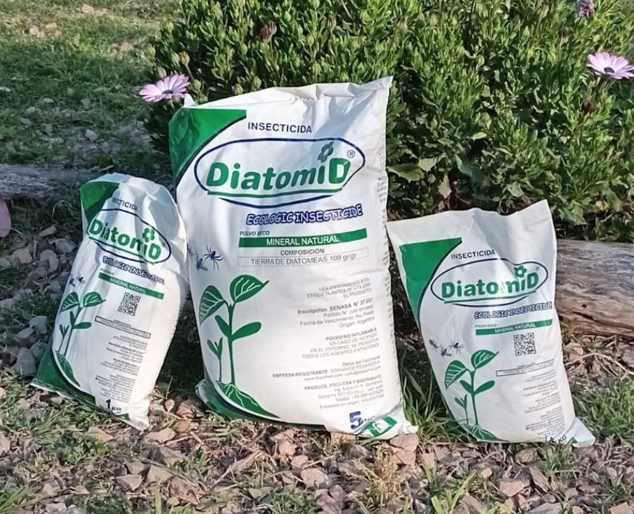 Tres bolsas de insecticida Diatomid colocadas sobre hierba y hojas al aire libre.