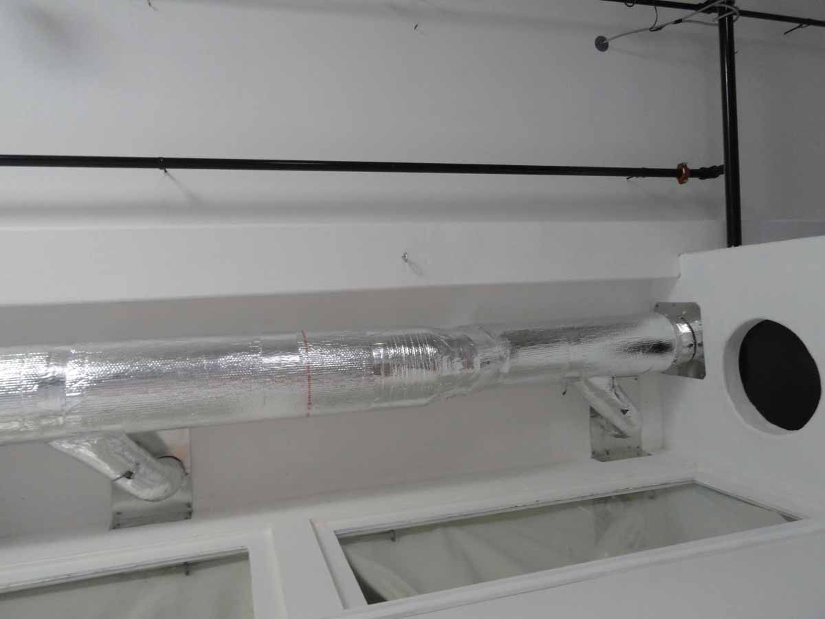 A pipe is hanging from the ceiling in a room.