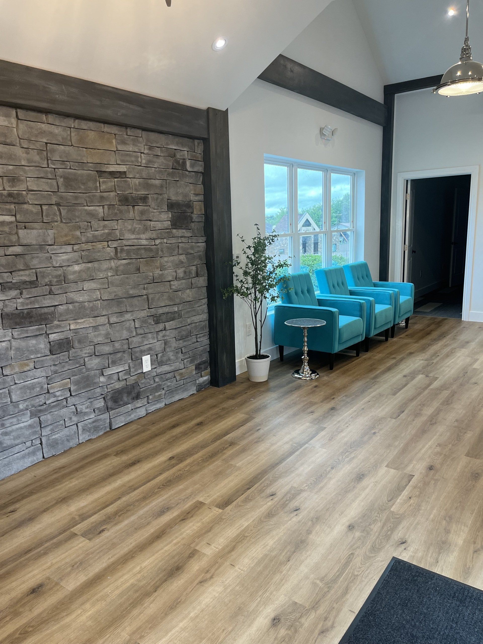 A living room with hardwood floors and a brick wall.