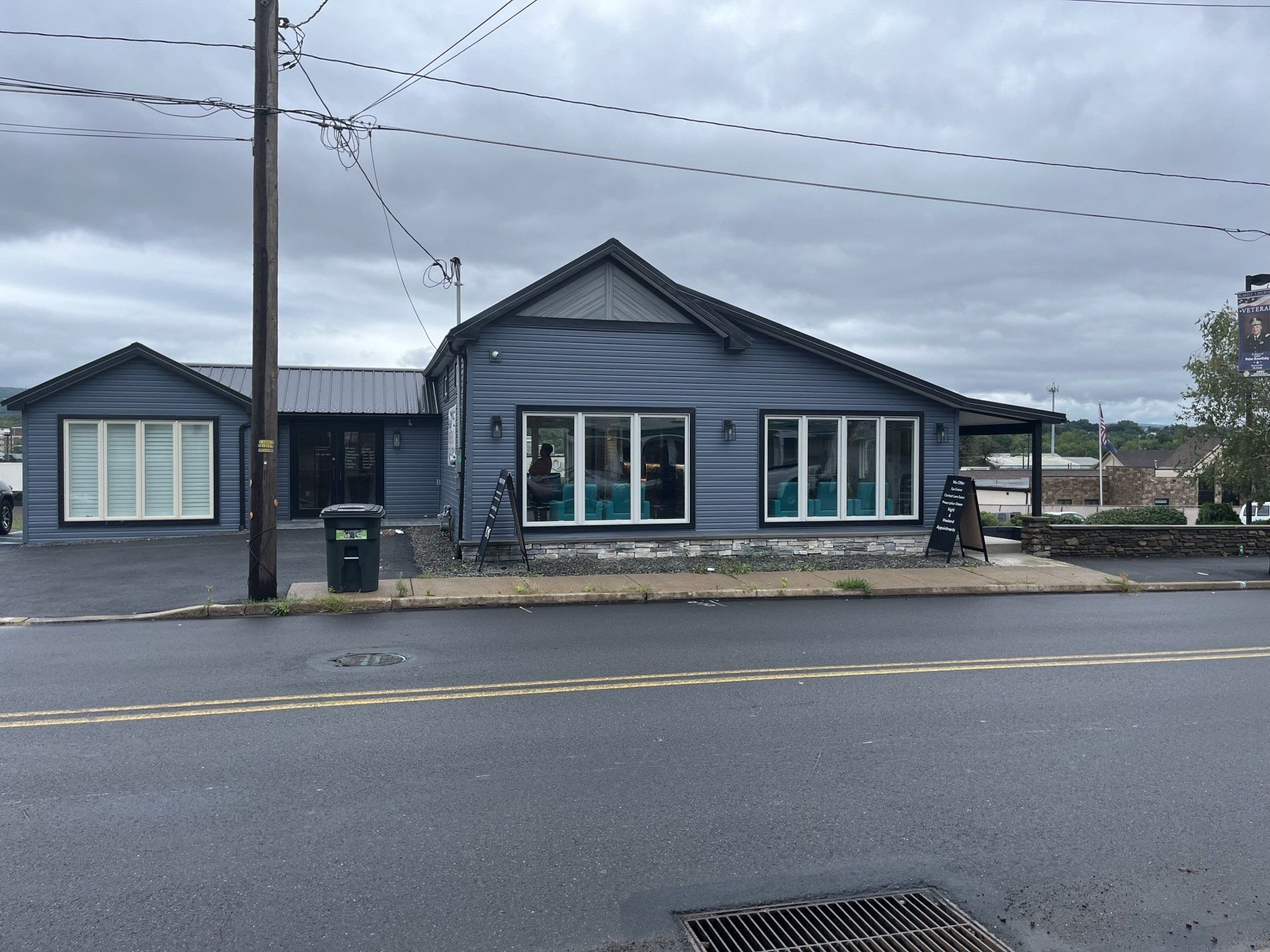 A blue building with a lot of windows is on the corner of a street.