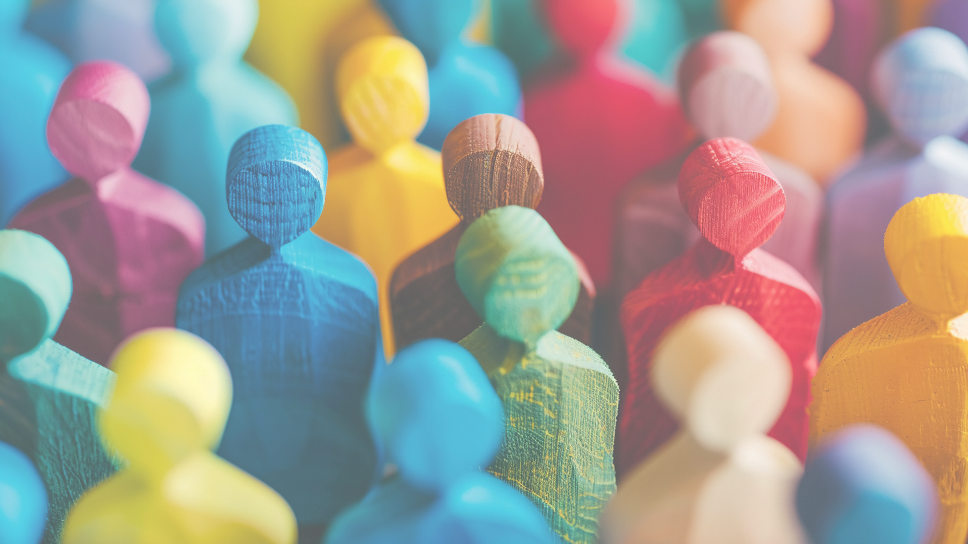Figurines made out of wood in the shape of people, with all being different colors.