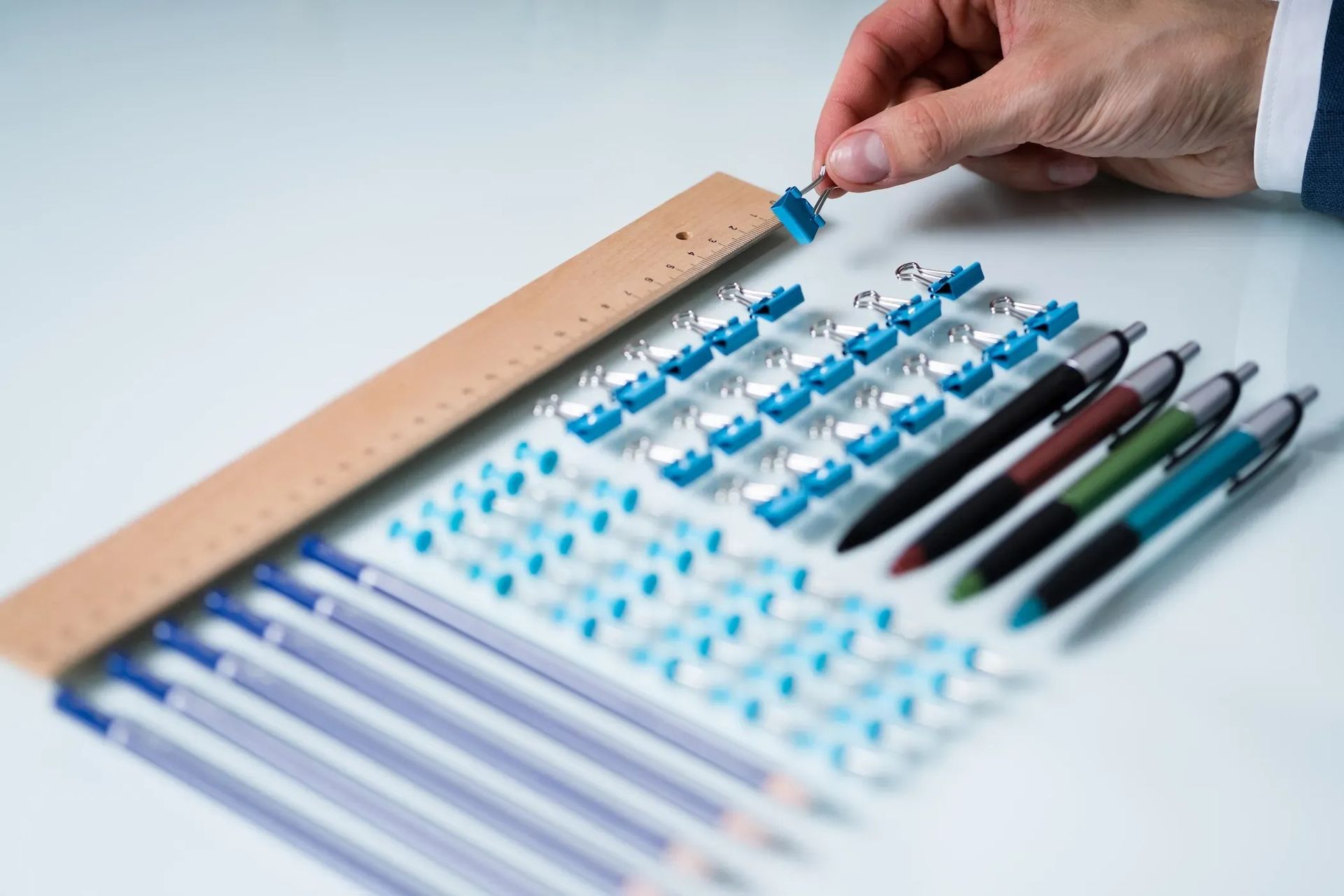Hand placing a blue-tipped pipette over a 96-well microplate with test tubes beside it