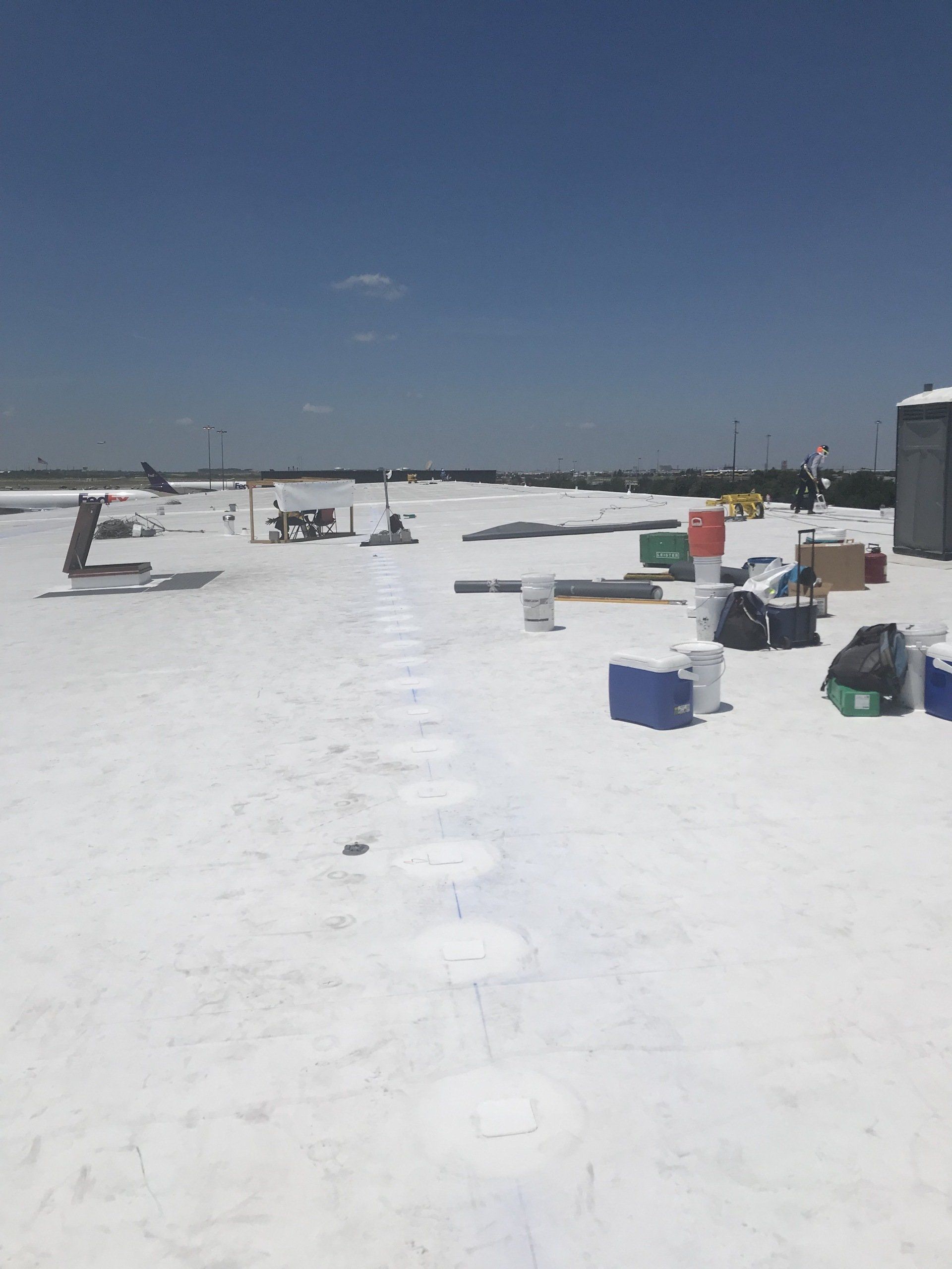 A snowy roof with buckets and coolers on it