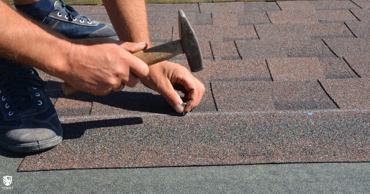 A person is hammering a nail into a roof with a hammer. A person is hammering a nail into a roof with a hammer.
