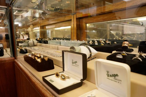 Jewelry store glass display cases filled with rings, cufflinks, and watch displays.
