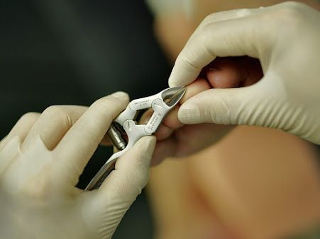 Des mains gantées examinent le pied d’un patient lors d’un examen médical du pied