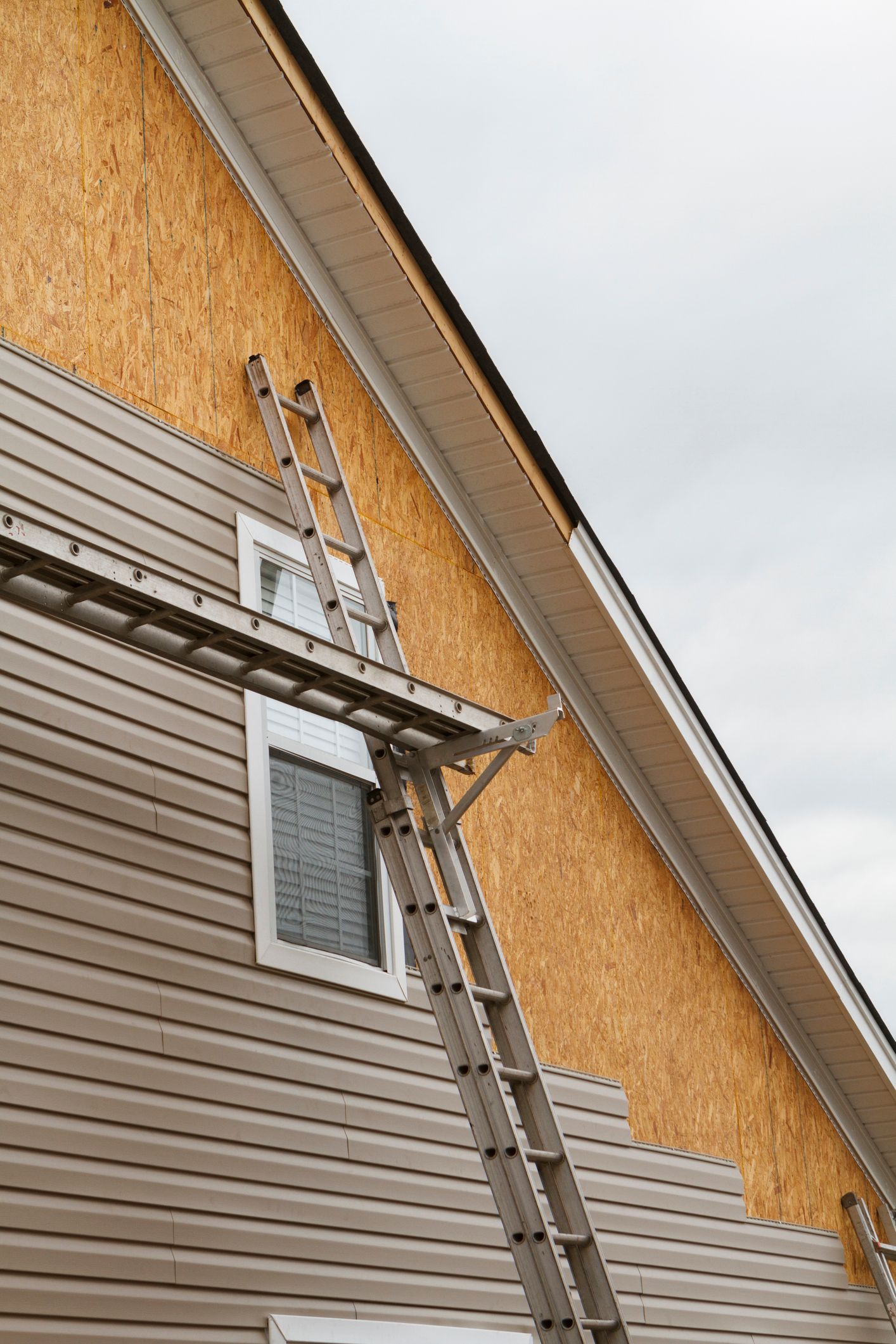 A man is working on the roof of a house.