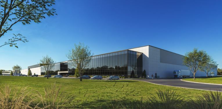 Entrepôt industriel moderne de plain-pied avec une grande façade vitrée, parking et aménagement paysager sous un ciel bleu.