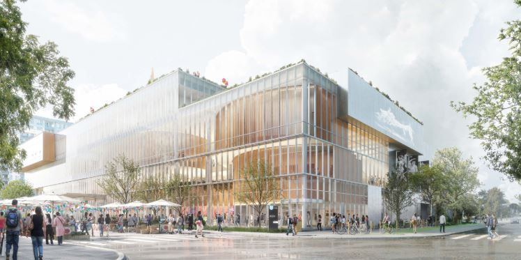 Un bâtiment moderne à plusieurs étages, fait de verre et de bois, où une foule de gens se promène et dîne aux tables en terrasse au niveau de la rue.