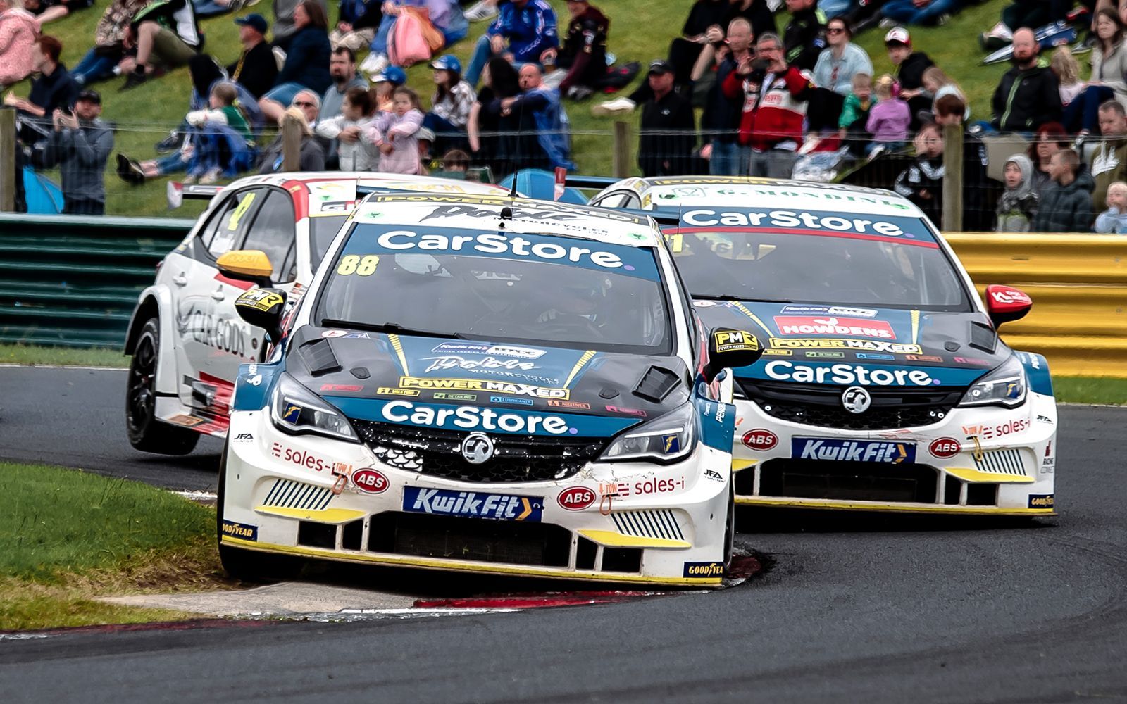 Two race cars are racing on a race track.