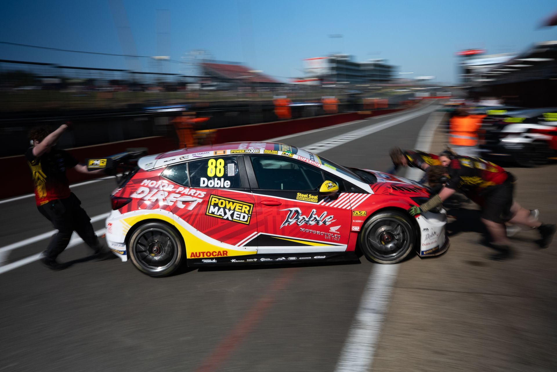 Mikey Doble's Vauxhall Astra being pushed out in pit lane by PMR mechanics BTCC 2025