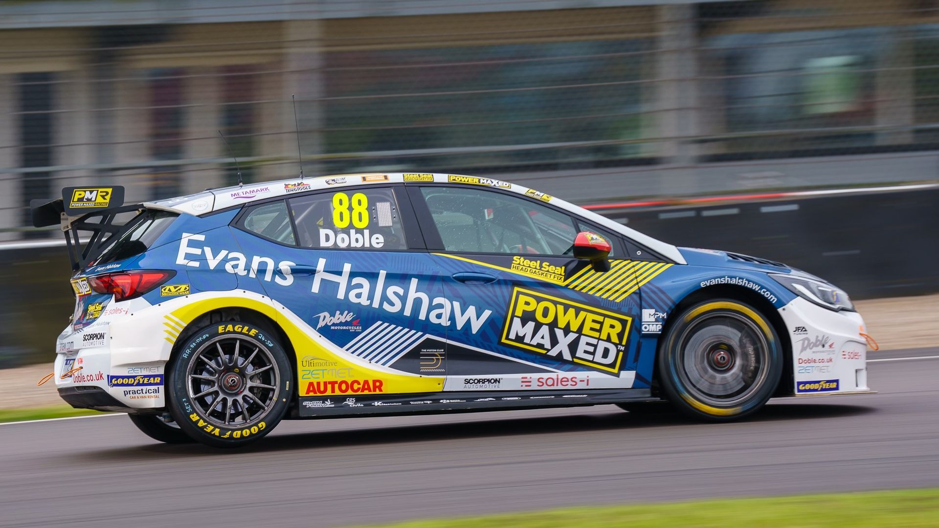 A blue and yellow race car is driving on a track.
