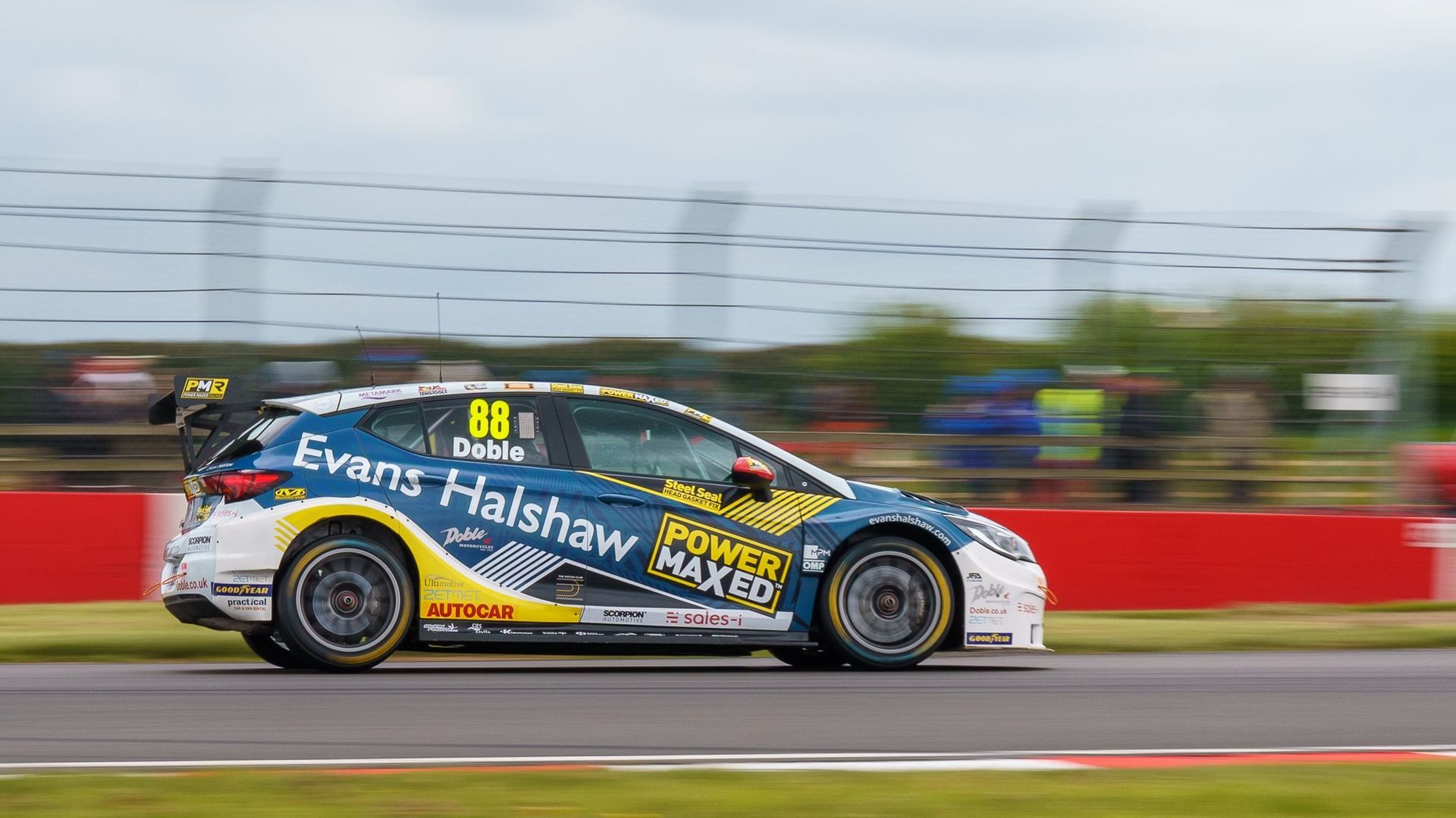 A blue and yellow race car is driving on a race track.