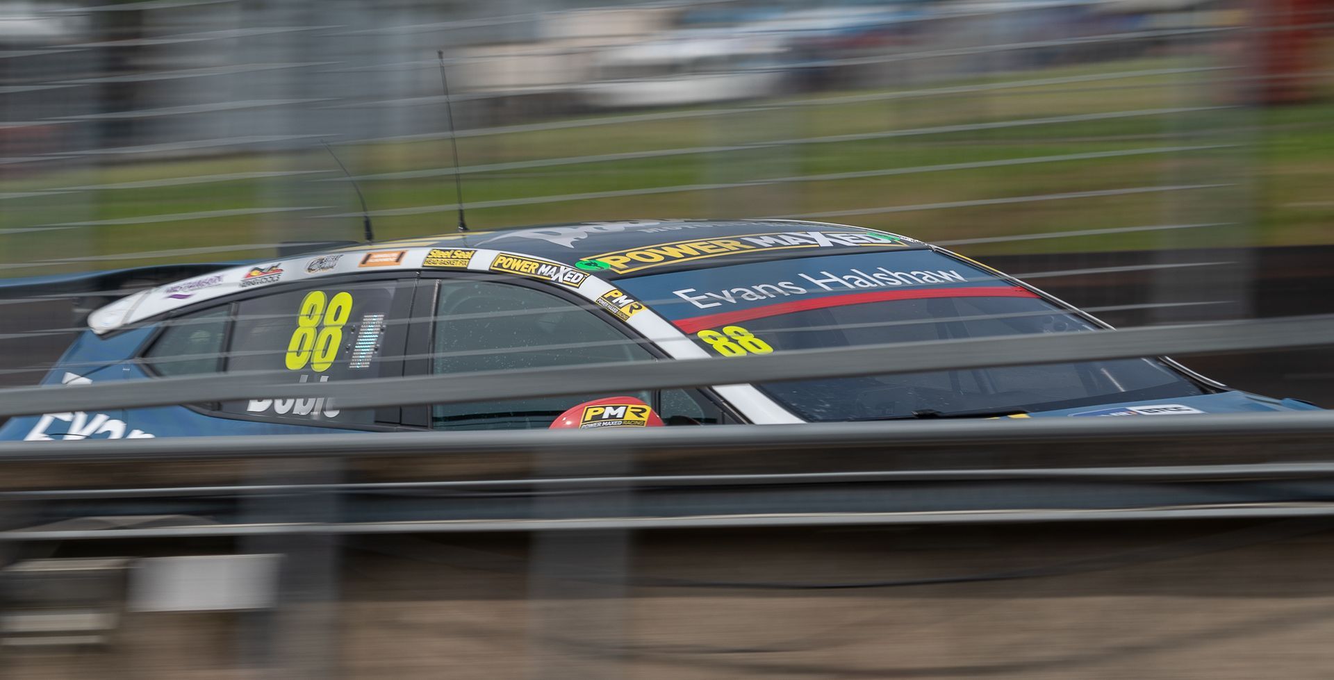 A race car with the number 88 on the side is driving down a track.