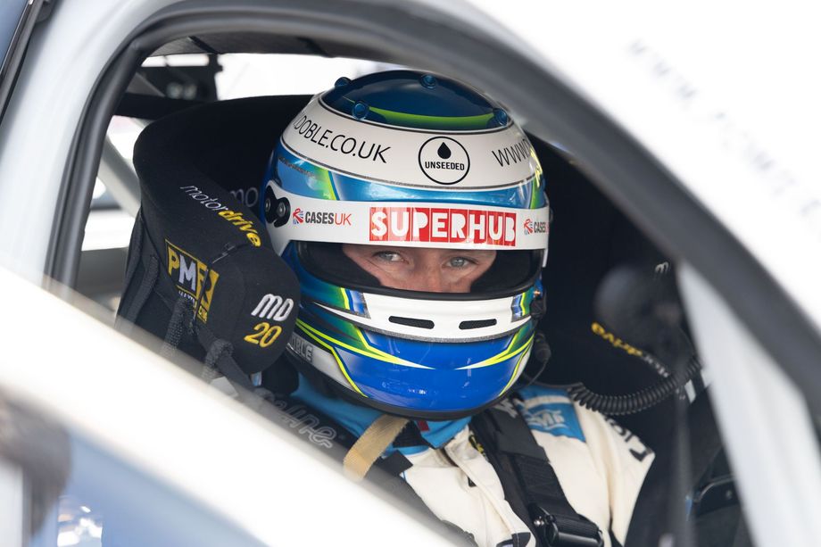 Mikey Doble racing around corner with Sponsors on front of car