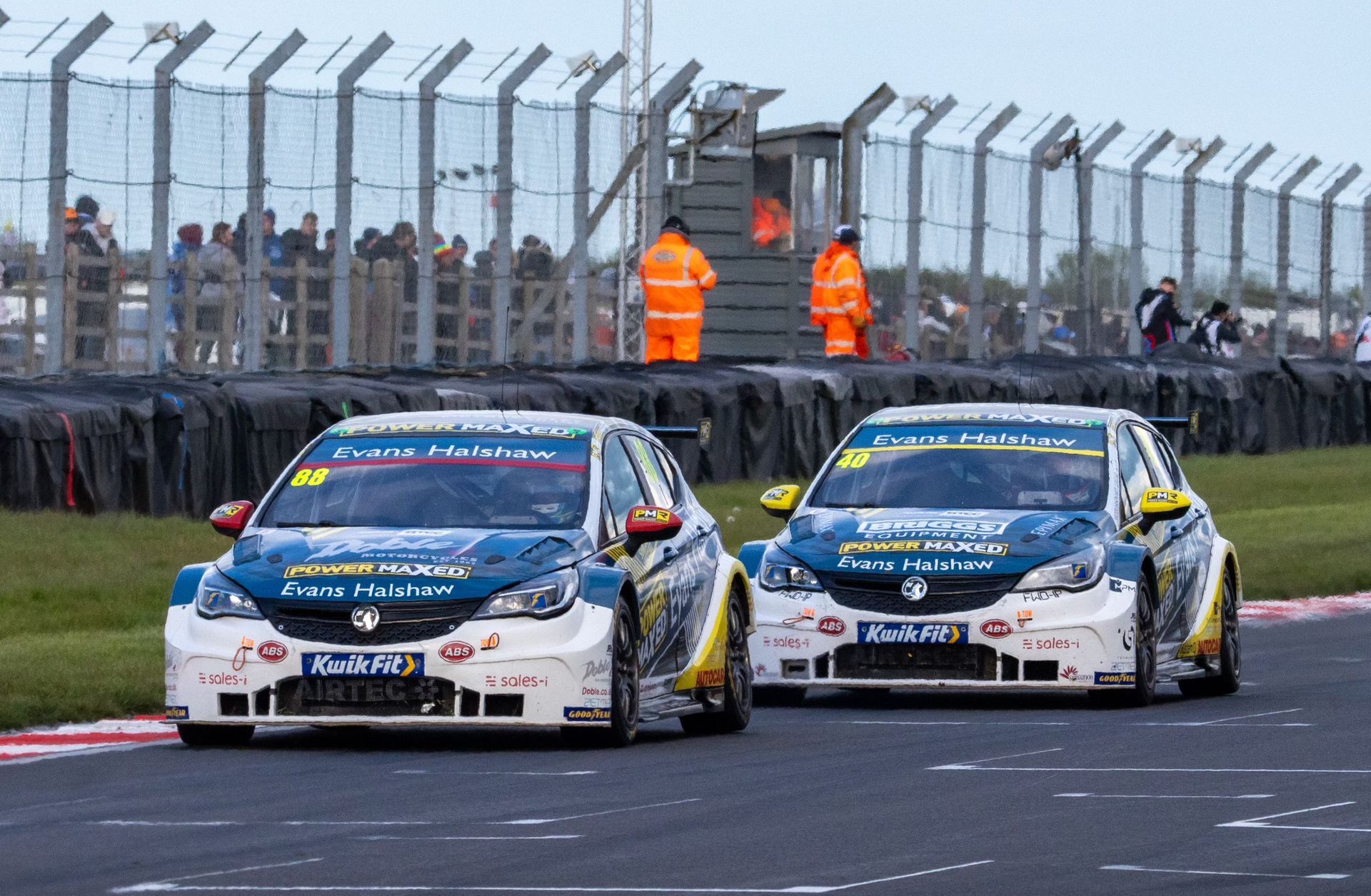 Two race cars are racing on a race track.