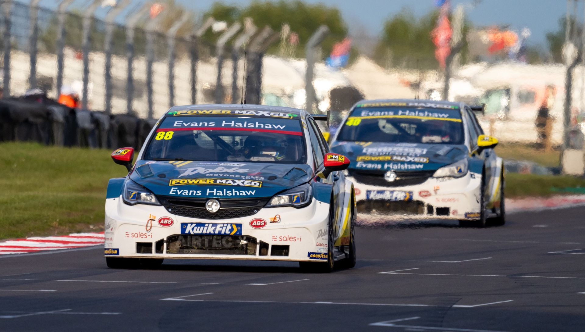 A group of race cars are driving down a track.