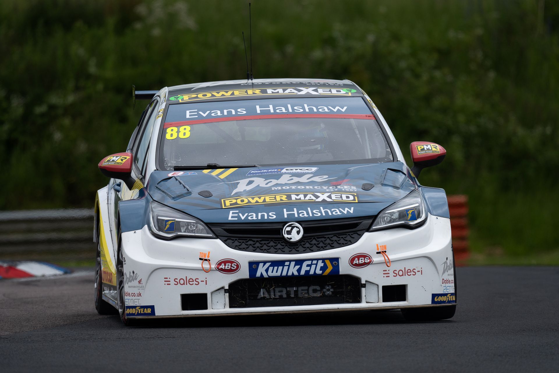 A race car is driving down a track with the number 88 on the front.