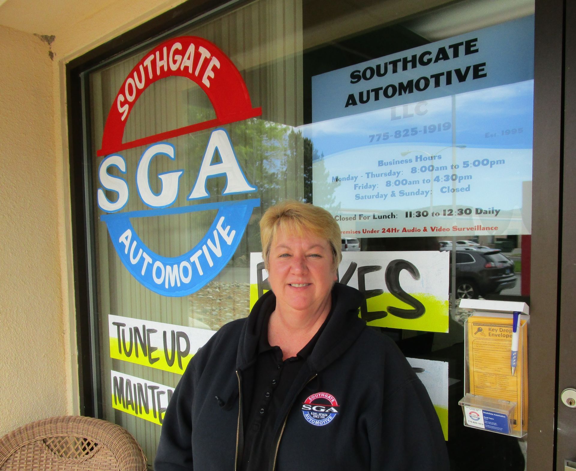 Woman stands outside Southgate Automotive, a shop with a colorful logo. | Southgate Automotive