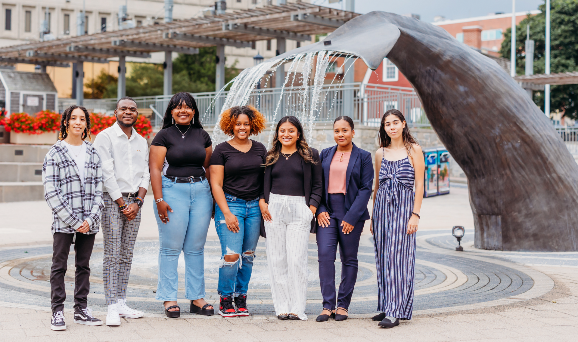 A group of people are posing for a picture in front of a fountain.