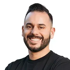 A man with a beard is smiling and wearing a black shirt.